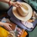 Close-up of woman packing her clothes in suitcase she is going in vacation
